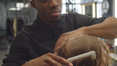 Afroamerikanischer-Friseur,-Der-Die-Haare-Eines-Männlichen-Kunden-Trennt